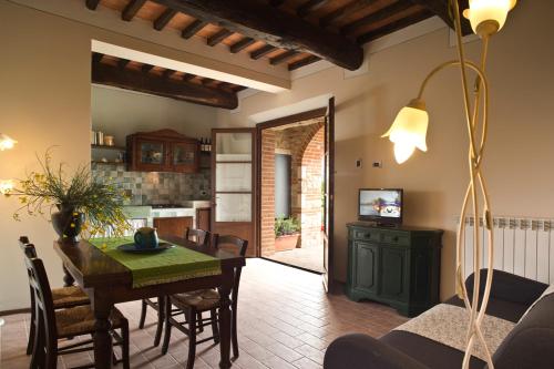 a kitchen and dining room with a table and chairs at Agriturismo Podere Campaini in Volterra