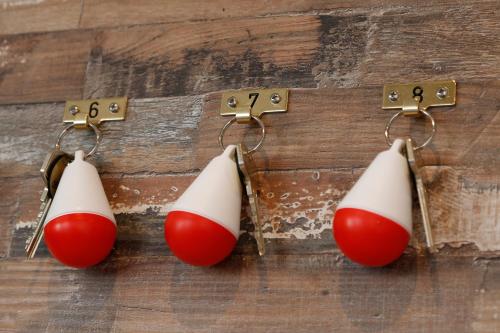 trois boucles d'oreilles rouges et blanches de Noël sur une table en bois dans l'établissement Hotelletje de Veerman, à Oost-Vlieland