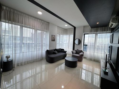 a living room with couches and a tv and windows at Arte Plus Ampang City 7Pax-3BR-2CP in Kuala Lumpur