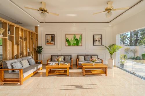 a living room with couches and tables at SaffronStays The Rajpur in Rājpur