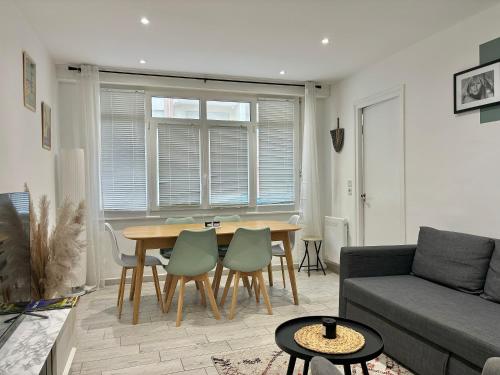 un salon avec une table, des chaises et un canapé dans l'établissement Le cocon du Touquet, à Le Touquet-Paris-Plage