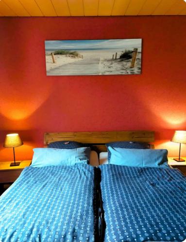 a bedroom with two beds with blue sheets and two lamps at Ramiwi am Teutoburger Wald in Oerlinghausen