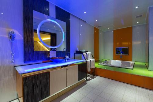 a bathroom with a sink and a large mirror at Soho Motel in Taoyuan