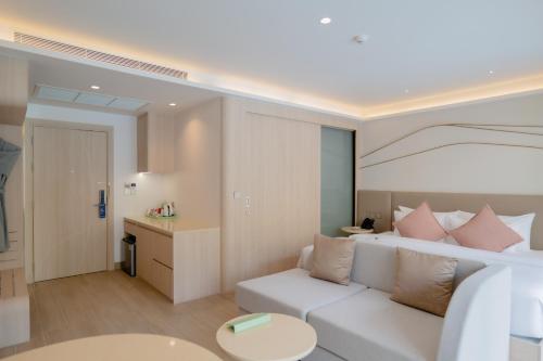 a living room with a white couch and a table at Wyndham Garden Naithon Phuket in Nai Thon Beach