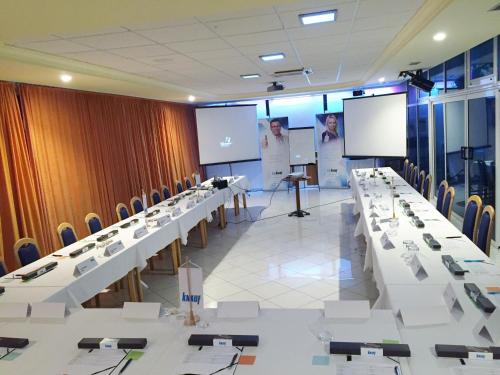 a conference room with tables and chairs and a screen at Hotel Panorama in Šibenik