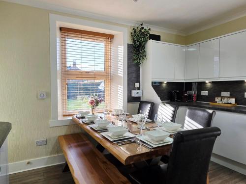 a dining room table with chairs and a kitchen at Inverness City 4 Bedroom house free parking in Inverness