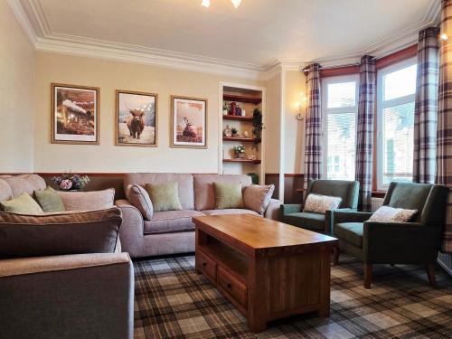 a living room with a couch and chairs and a table at Inverness City 4 Bedroom house free parking in Inverness