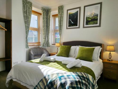 a bedroom with a large bed with green and white pillows at Inverness City 4 Bedroom house free parking in Inverness