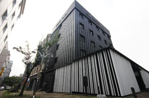 a large black and white building on a city street at Hotel YAJA Gwangju Hanam branch in Gwangju