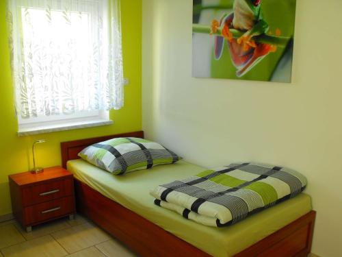 a small bedroom with a bed and a window at Pension Froschprinz in Seligenstadt