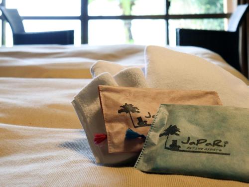 a bed with two pillows with palm trees on it at Japari Tateyama - Vacation STAY 75921v in Tateyama