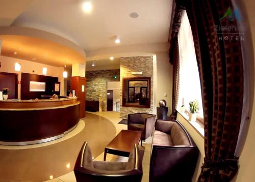 a lobby with leather chairs and a bar at Hotel Zieleniec in Zieleniec