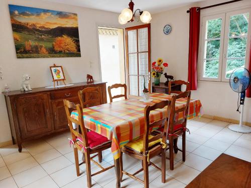 une salle à manger avec une table et des chaises dans l'établissement L'orée du bois, à La Fournerie