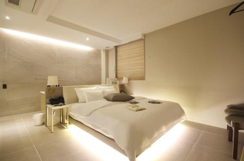 a bedroom with a large white bed and a lamp at Hotel YAJA Gwangju Hanam branch in Gwangju