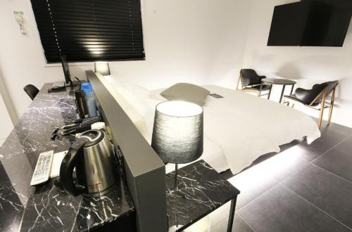 a bedroom with a desk with a bed and chairs at Hotel YAJA Gwangju Hanam branch in Gwangju