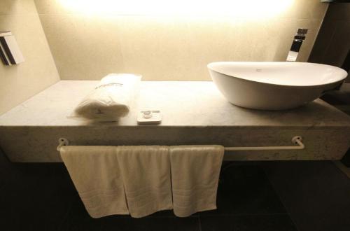 a bathroom with a sink and towels on a counter at Hotel YAJA Gwangju Hanam branch in Gwangju