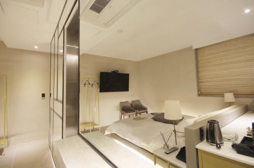 a room with a bed and a desk with a television at Hotel YAJA Gwangju Hanam branch in Gwangju