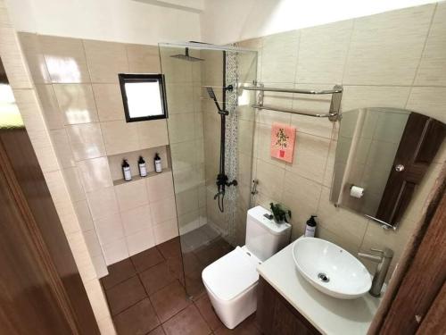 a bathroom with a toilet and a sink and a shower at Overlooking & Serene Resthouse wt Pool in Antipolo in Antipolo