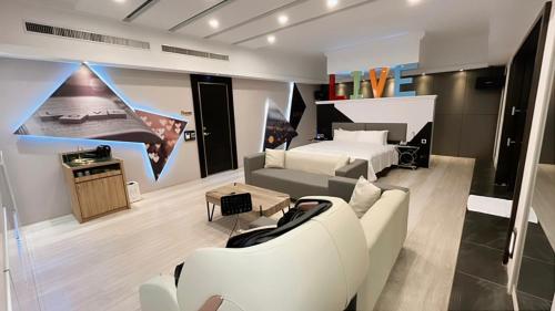 a living room with a couch and a bed at Soho Motel in Taoyuan