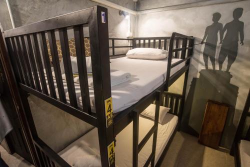 a room with two bunk beds and a shadow of people on the wall at Beehive Phuket Old Town Hostel in Phuket Town