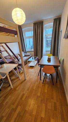 ein Wohnzimmer mit einem Tisch und einem Etagenbett in der Unterkunft Holiday Everyday - Berlin Calling in Berlin