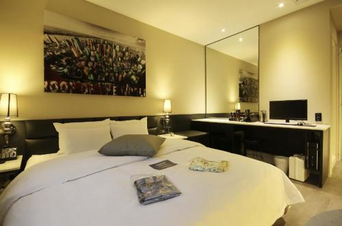 a bedroom with a large white bed and a desk at Hotel YAJA Gwangju Hanam branch in Gwangju