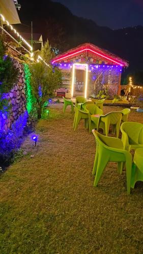 a row of green chairs in front of a building with lights at Cradle of Life in Shivpuri