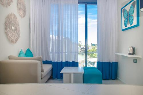 a living room with a couch and a window at Azur Paradise Hotel & Rooftop Bar in Grand Baie