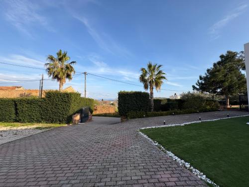 a brick walkway with palm trees in a park at Residenza di Lusso in Chios