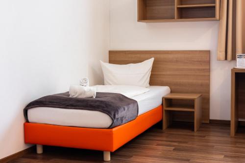 a bedroom with a bed with an orange bed frame at Orange Hotel und Apartments in Neu Ulm