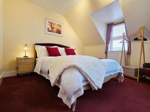a bedroom with a large bed with red pillows at Inverness City 4 Bedroom house free parking in Inverness