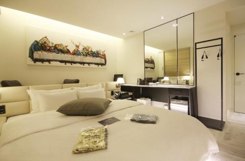 a bedroom with a large white bed and a mirror at Hotel YAJA Gwangju Hanam branch in Gwangju
