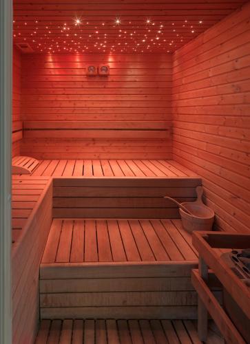 a wooden sauna with a bench and lights in it at Parkhotel Fedora in Campitello di Fassa
