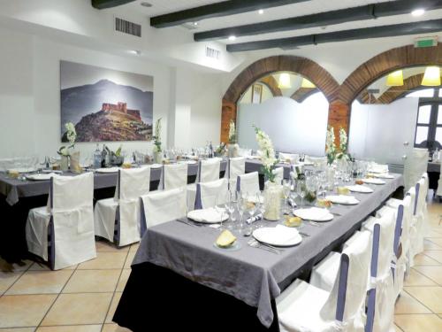 a large banquet hall with white tables and white chairs at Hotel Virrey in Arnedo