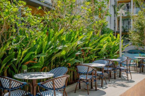 a row of tables and chairs with plants at Wyndham Garden Naithon Phuket in Nai Thon Beach