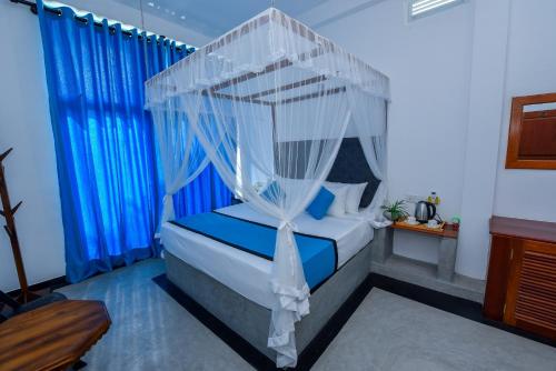 a bedroom with a bed with a canopy at Camellia Unawatuna in Unawatuna