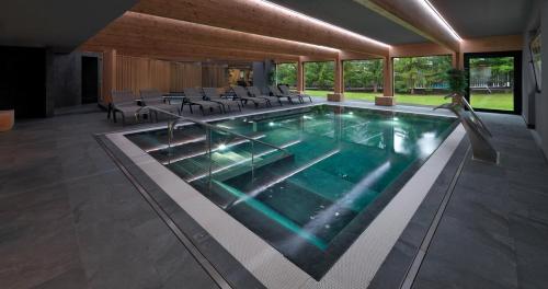 a large swimming pool with chairs in a building at Parkhotel Fedora in Campitello di Fassa