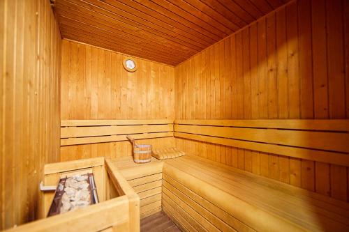 a wooden sauna with a tub and a clock at Barceló Illetas Albatros - Adults Only in Illetas