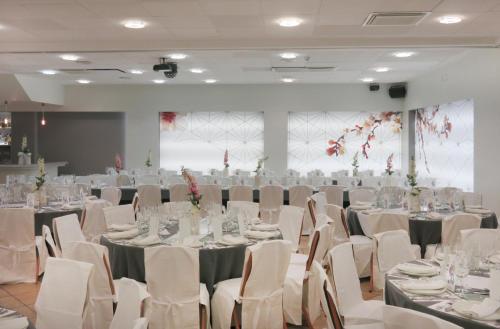 a banquet hall with white tables and white chairs at Hotel Virrey in Arnedo