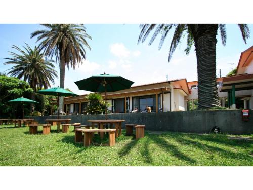 a group of tables and umbrellas in front of a building at Japari Tateyama - Vacation STAY 84008v in Tateyama