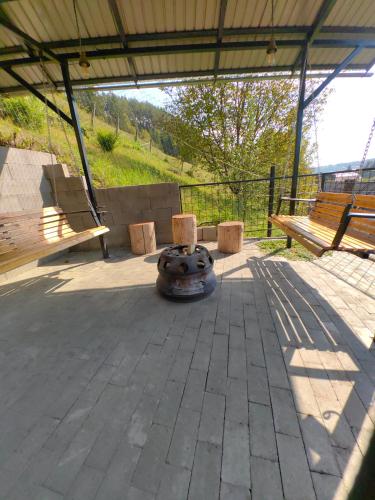 a patio with two benches and a fire pit at Casa MATEO in Topliţa