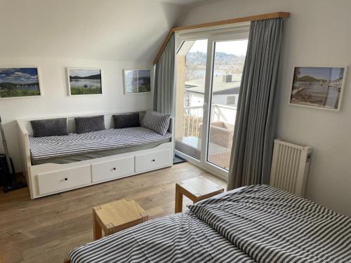 a bedroom with two beds and a balcony at Gemutliche 93m2Fewo mit 2 Schlafzimmern und seitlichem Seeblick vom Balkon in Scheid