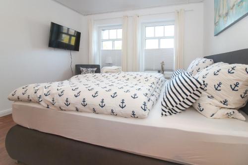 a bedroom with a bed with blue and white sheets and pillows at Brise8 - Greetsiel in Krummhörn