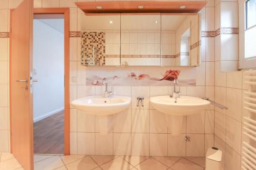 a bathroom with two sinks and a mirror at Brise8 - Greetsiel in Krummhörn