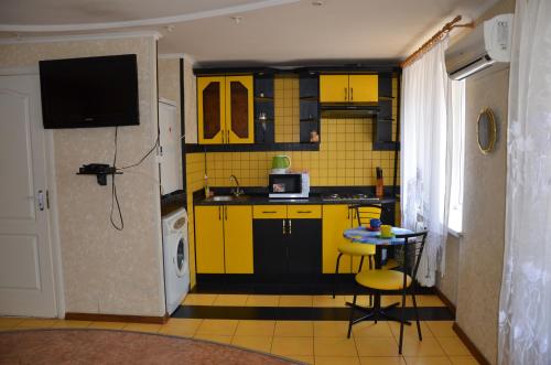 a kitchen with yellow cabinets and a table in it at Apartment on Ingenernaya 17 in Mykolaiv