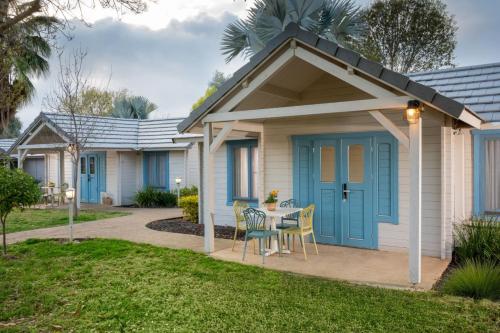 a house with a blue door and a table and chairs at The Village- Jordan Riverside Travel Hotel in Sde Nehemia