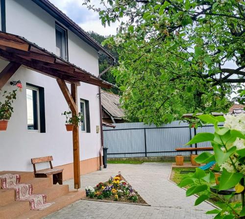 a courtyard of a house with a bench and flowers at Casa MATEO in Topliţa
