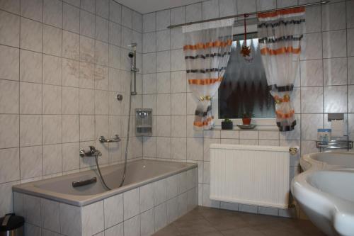 ein Badezimmer mit einer Badewanne und einem Waschbecken in der Unterkunft Ferienwohnung Fam. Höhn in Kappel-Grafenhausen
