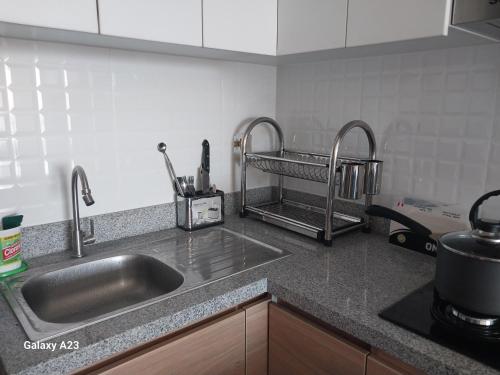 a kitchen with a sink and two faucets at Moderno departamento con vista panorámica cerca a los centros comerciales in Lima