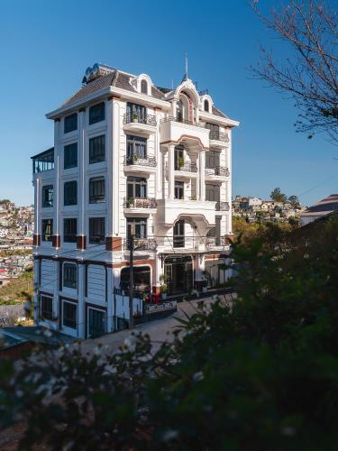 a tall white building sitting on top of a street at Lumina Dalat Premium in Xuan An